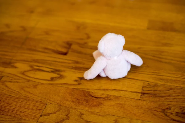 Teddybear kecil duduk di lantai kayu — Stok Foto
