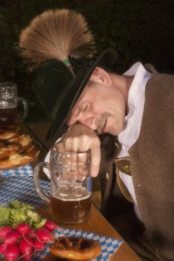 drunk bavarian man at Oktoberfest at table clipart
