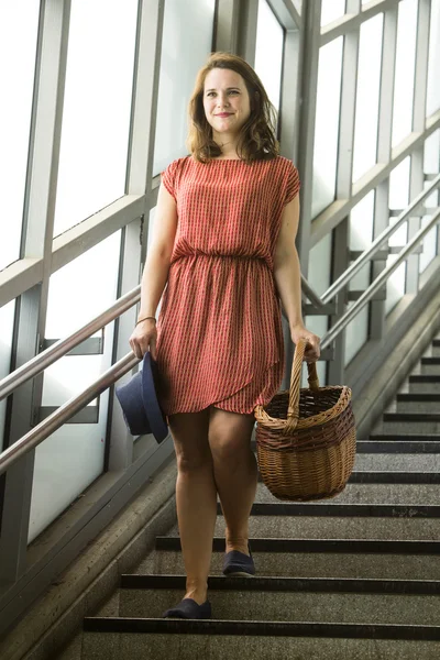 Jovem mulher andando em escadas segurando uma cesta — Fotografia de Stock