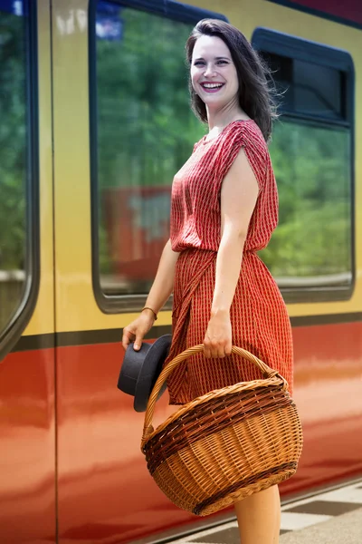 Young woman standing in front of train at station — Stock Photo, Image