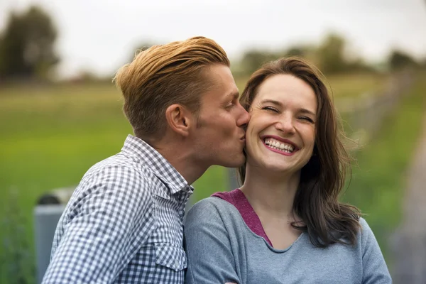 Мужчина целует женщину на щеку — стоковое фото