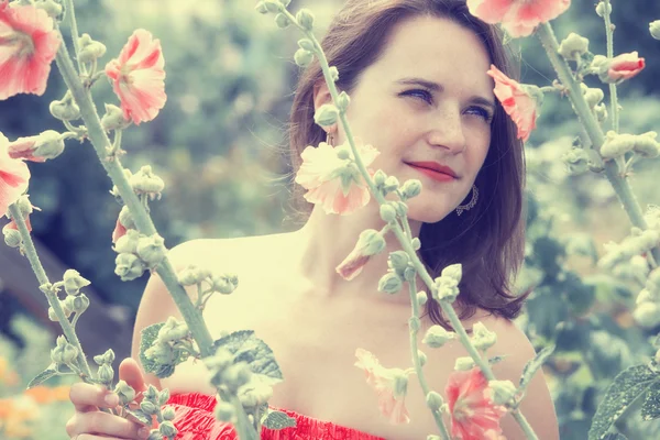 Porträtt av ung kvinna i fält av blommor — Stockfoto