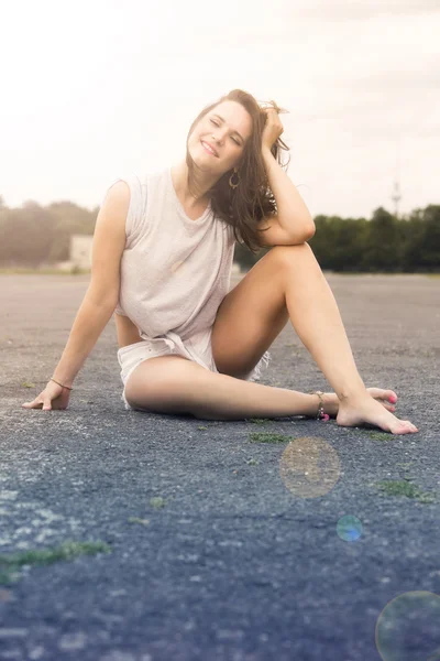 Jonge vrouw in korte broek zitten op de stoep — Stockfoto