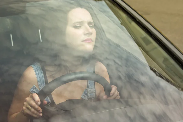 Jeune femme assise en voiture et conduisant prudemment — Photo