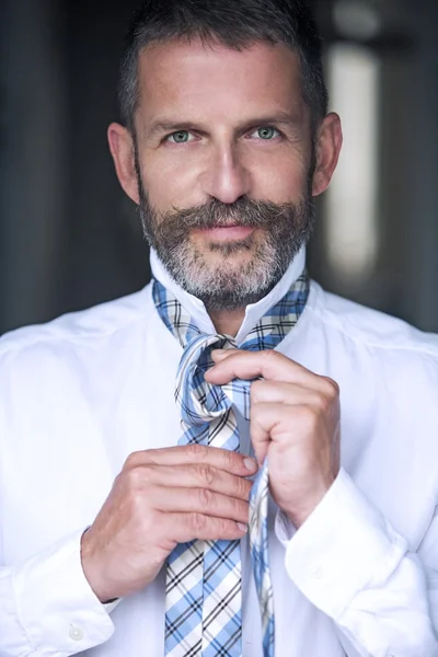 Hombre guapo atando su corbata — Foto de Stock