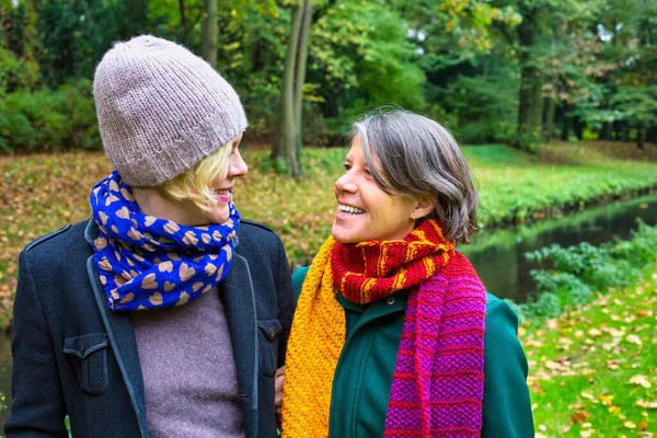 Dos Mujeres Sus Años Abrazándose Caminando Parque Otoño —  Fotos de Stock