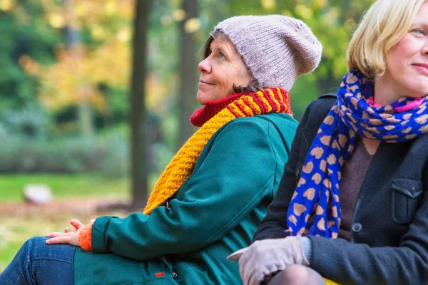 Yaşlarda Iki Kadın Sonbaharda Parkta Bankta Oturuyor — Stok fotoğraf