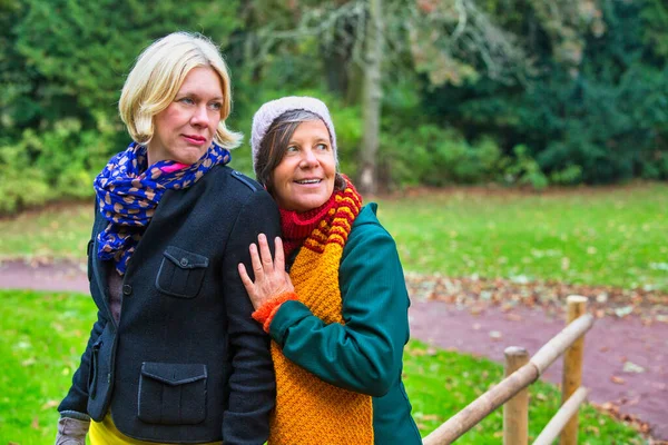 Dos Mujeres Años Abrazándose Sonriendo Parque Otoño —  Fotos de Stock