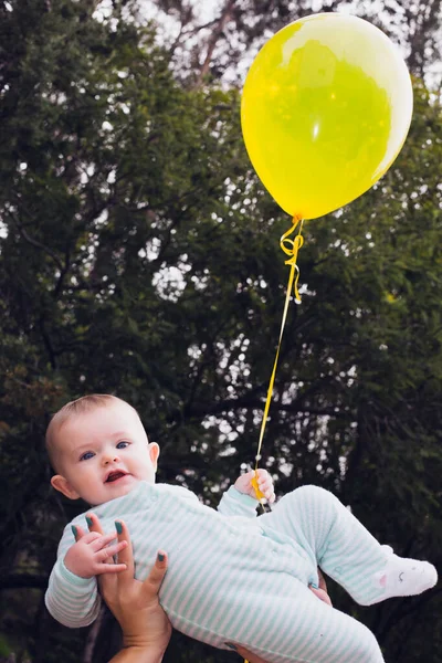 Bebê Feliz Com Balão Amarelo Realizada Alto Por Sua Mãe — Fotografia de Stock