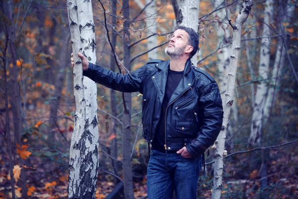 Przystojny Mężczyzna Skórzanej Kurtce Dżinsach Stojących Lesie — Zdjęcie stockowe