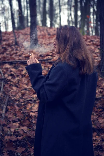 Młoda Brunetka Kobieta Palenie Papierosów Lesie Jesienią — Zdjęcie stockowe