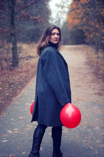 Sonbaharda Ormanda Elinde Iki Kırmızı Balonla Siyah Ceketli Genç Bir — Stok fotoğraf