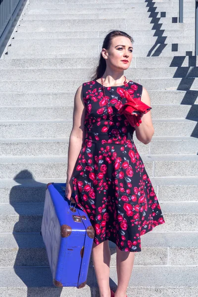 Молодая Брюнетка Красном Платье Голубой Чемодан Стоящий Лестнице Вокзале — стоковое фото