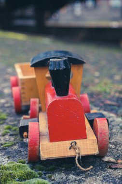 Arka planda büyük bir tren olan küçük tahta oyuncak treninin yakın çekimi.