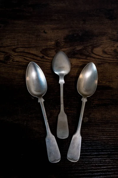 Tres Cucharas Yacen Una Mesa Mientras Que Una Encuentra Revés —  Fotos de Stock