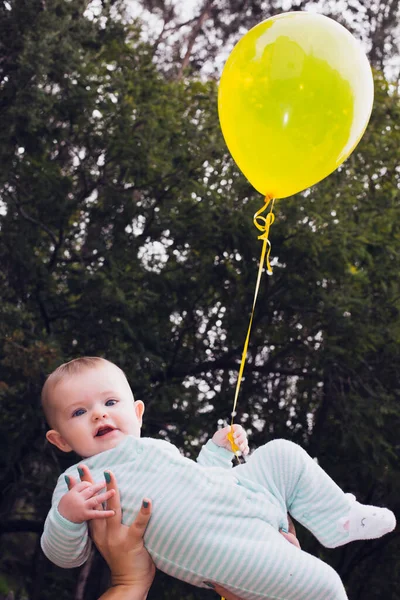 Happy Baby Yellow Balloon Held High Air Her Mother — Stock Photo, Image
