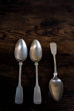 Üç kaşık bir masada yatarken, bir kaşık da diğer tarafta yatıyor.