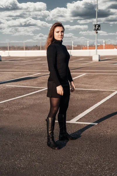 Young Brunette Woman Black Clothes Boots Standing Empty Parking Lot — Stock Photo, Image