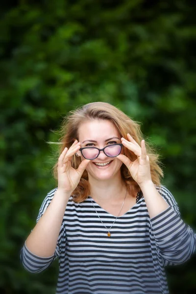 肖像画だ 公園に立っている眼鏡をかけたブルネットの若い女性 — ストック写真
