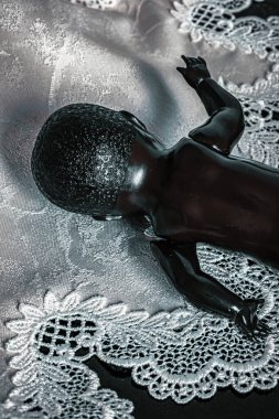 Beyaz dantelli siyah bebeğin arkası.