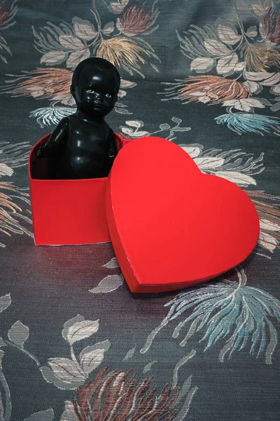 Çiçekli Arka Planda Kalp Şeklinde Bir Kutuda Siyah Bebek — Stok fotoğraf