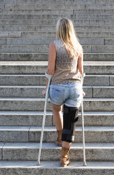 Blonde woman with crutches — Stock Photo, Image