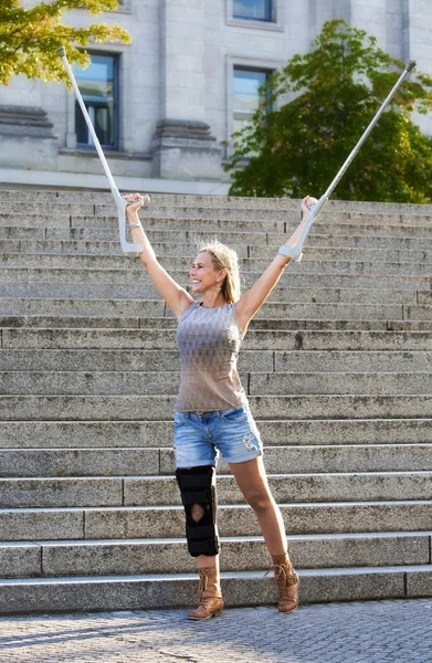 Mujer rubia con muletas — Foto de Stock