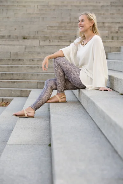 Mujer rubia sentada en escaleras — Foto de Stock