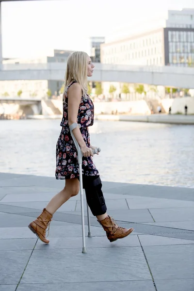 blonde woman with crutches