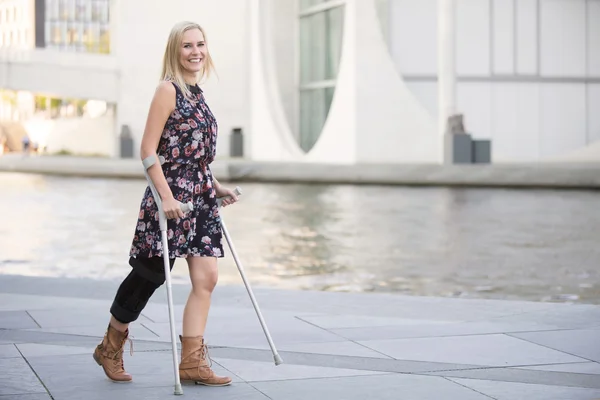 Blonde woman with crutches — Stock Photo, Image