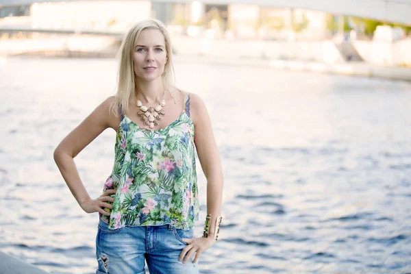 Woman standing in front of a river — Stock Photo, Image