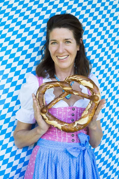 Femme en dirndl avec bretzel — Photo