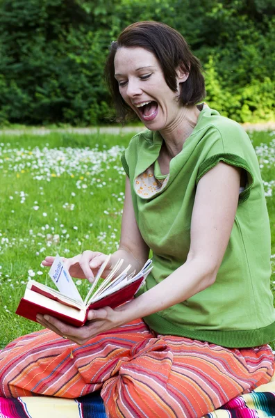 Žena v parku s knihou — Stock fotografie