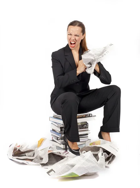Business woman sitting on a stack of books and screams — стоковое фото