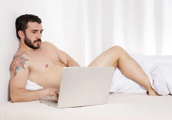 Mannen i sängen med laptop — Stockfoto