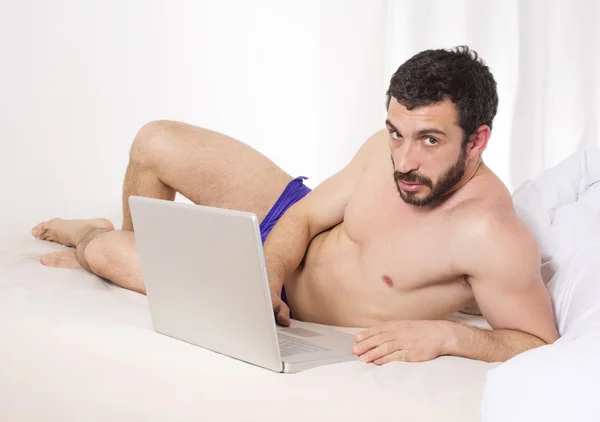 Mannen i sängen med laptop — Stockfoto