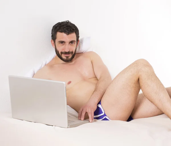 Homem na cama com laptop — Fotografia de Stock