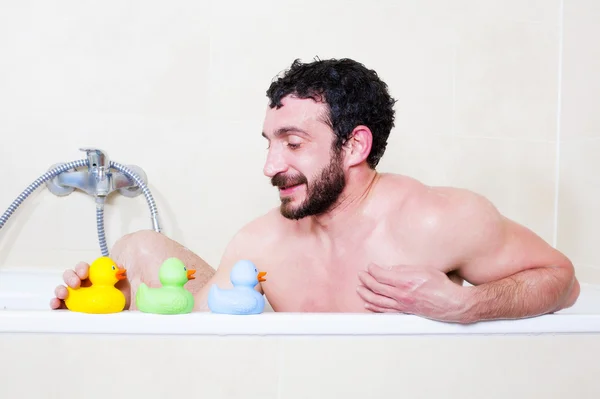 Hombre en bañera con pato de goma — Foto de Stock