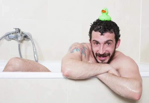 Uomo in vasca con anatra di gomma — Foto Stock