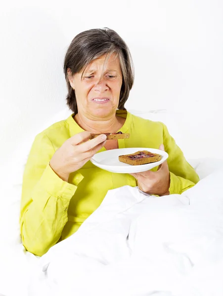 Kvinna i sängen med rostat bröd — Stockfoto