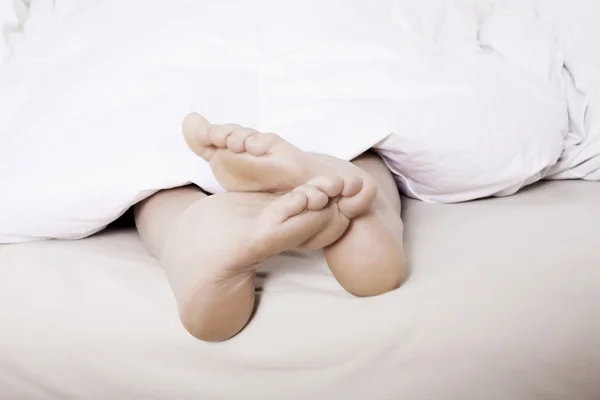 Feet in bed — Stock Photo, Image