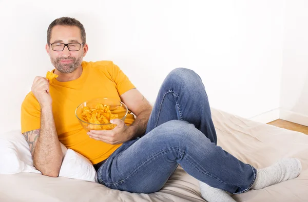 Mannen äter potatischips — Stockfoto