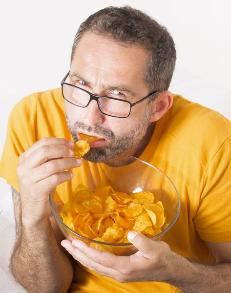 Mannen äter potatischips — Stockfoto