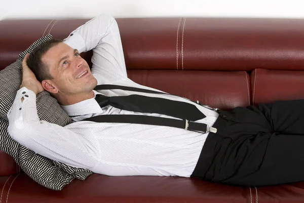 Businessman laying on couch — Stock Photo, Image