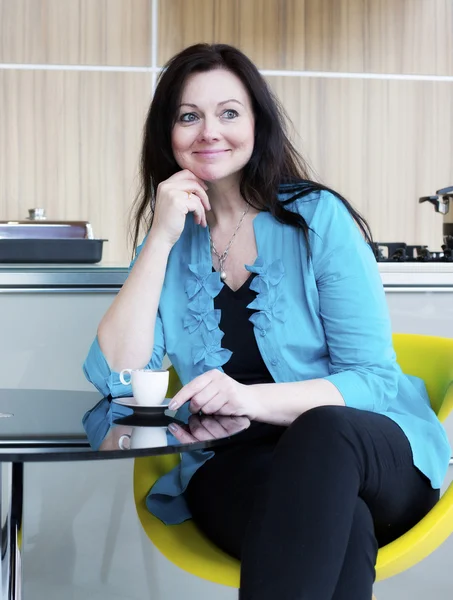 Vrouw drinkt koffie in de keuken — Stockfoto