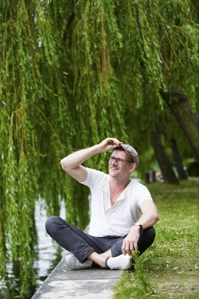 Mann sitzt am Wasser — Stockfoto