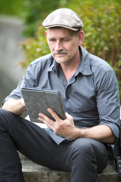 Homem no parque com tablet — Fotografia de Stock