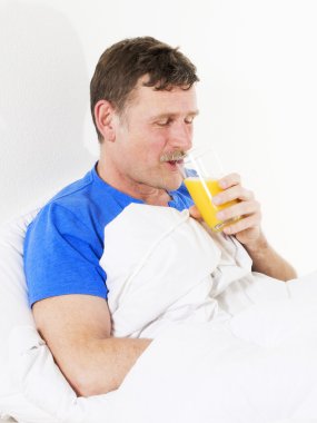 portakal suyu ile yatakta adam