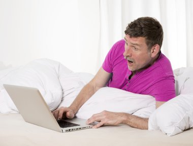 dizüstü bilgisayar ile yatakta adam