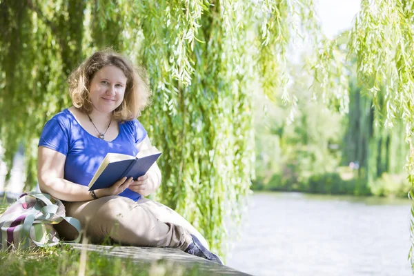 Jonge vrouw die een boek leest — Stockfoto